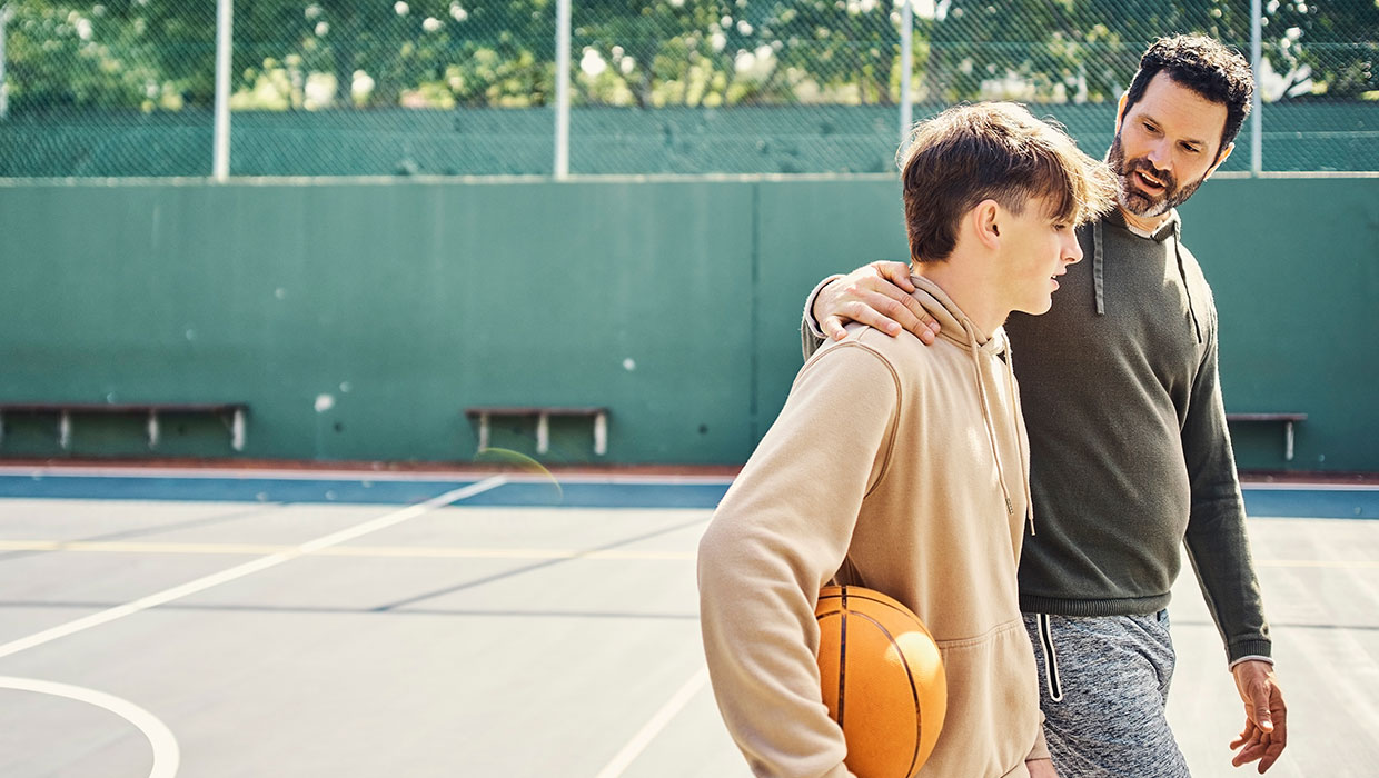 Dad talking to son on basketball court