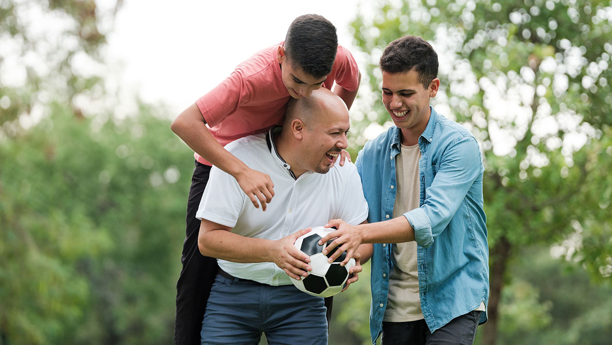 Dad playing soccer with his sons