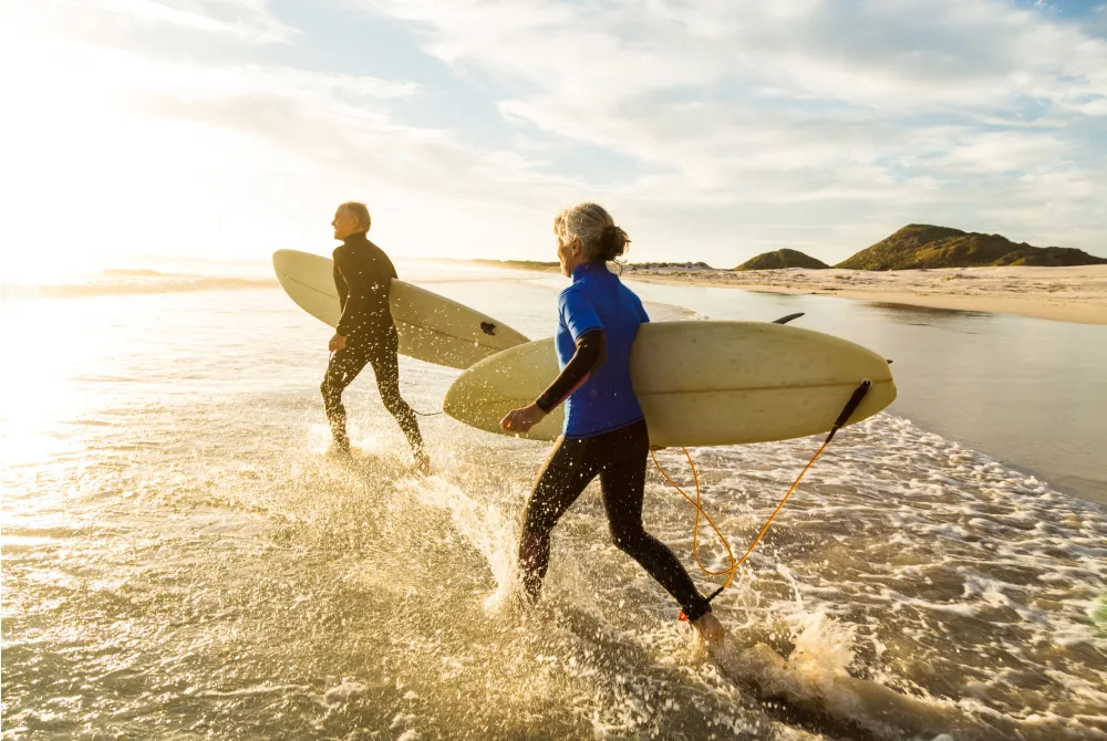 mature couple heading out to surf