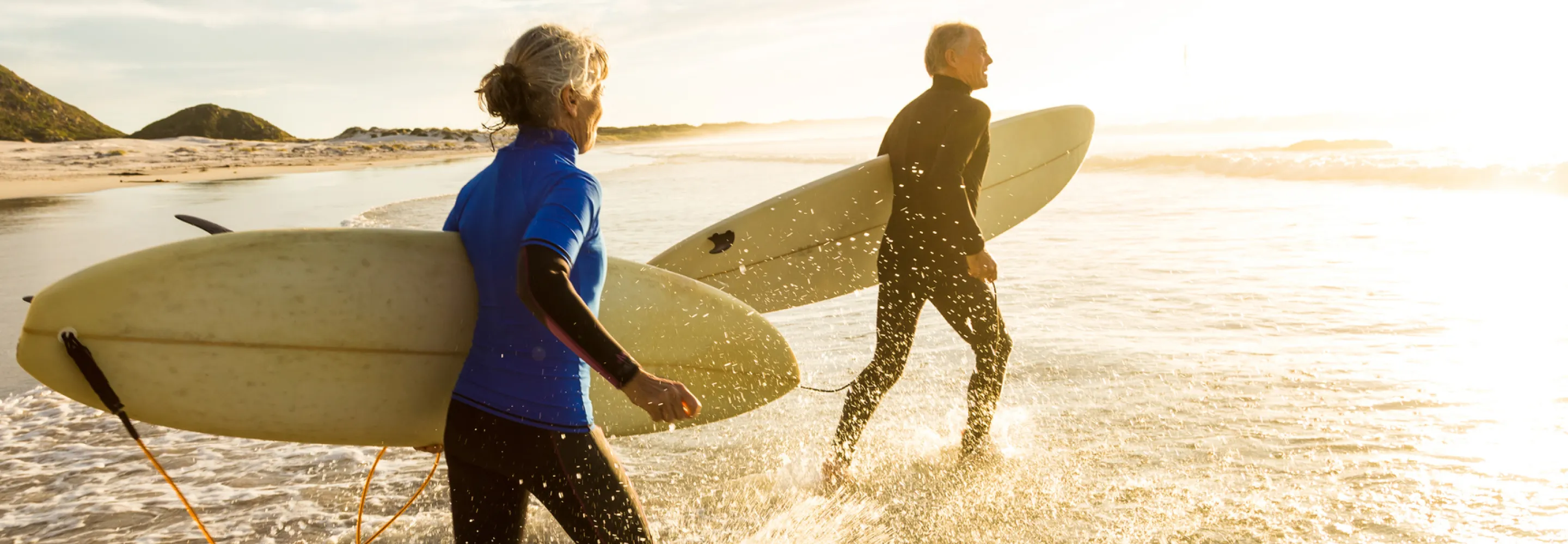 mature couple heading out to surf