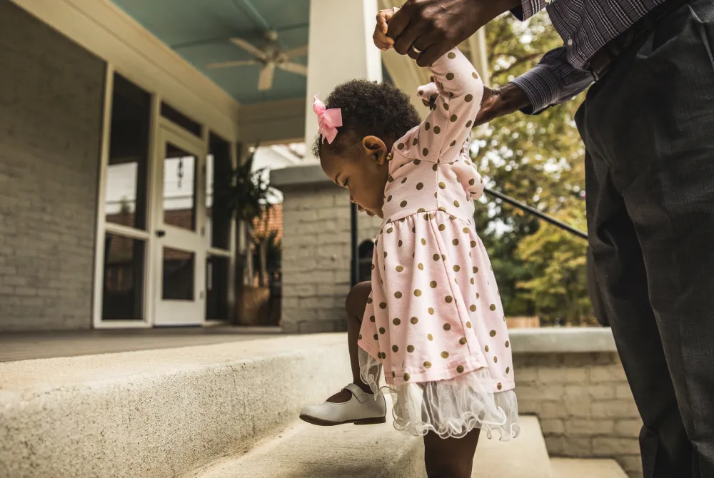 Man helping toddler climb steps