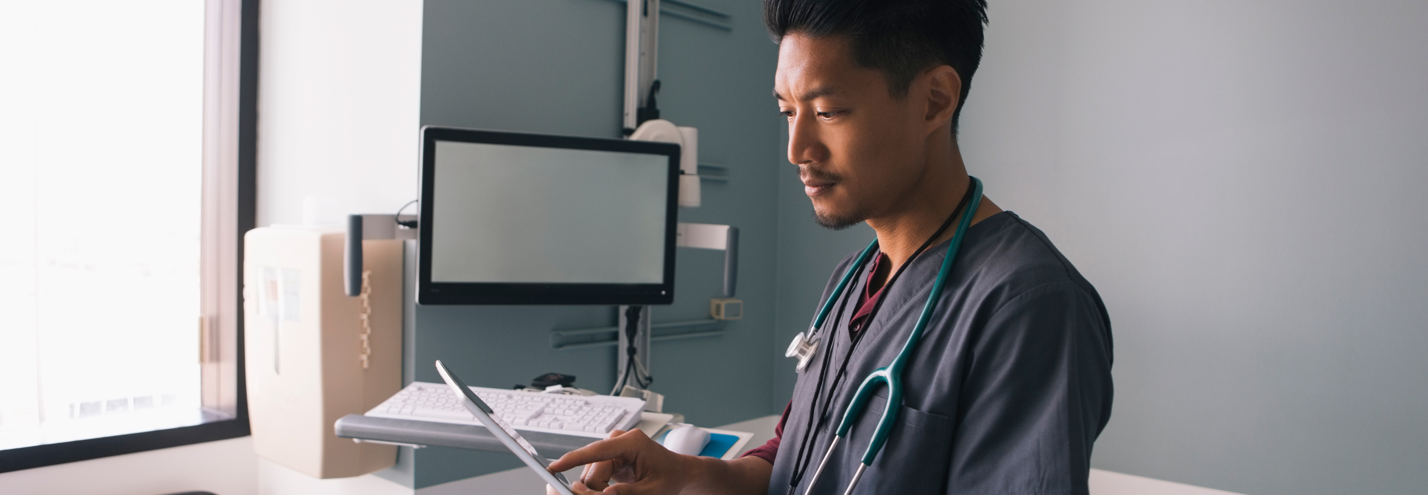 Male nurse looking at information on a tablet