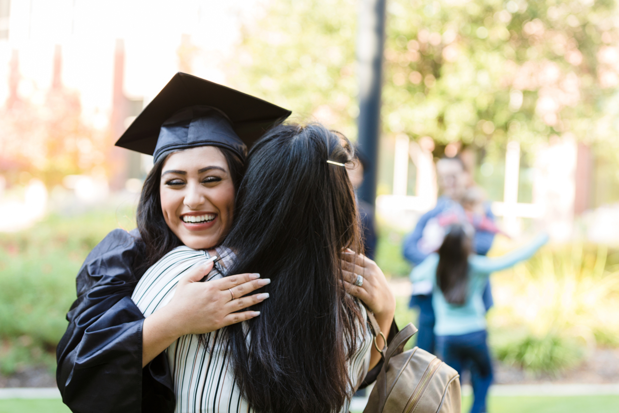 young woman hugs mother after graduation