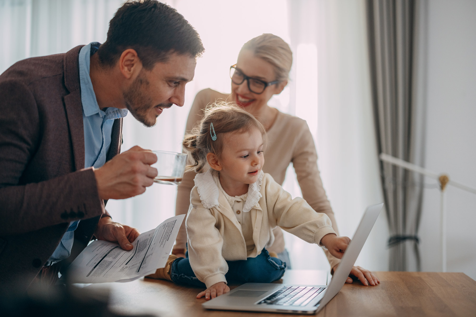 Parents and child looking at a laptop together at home.