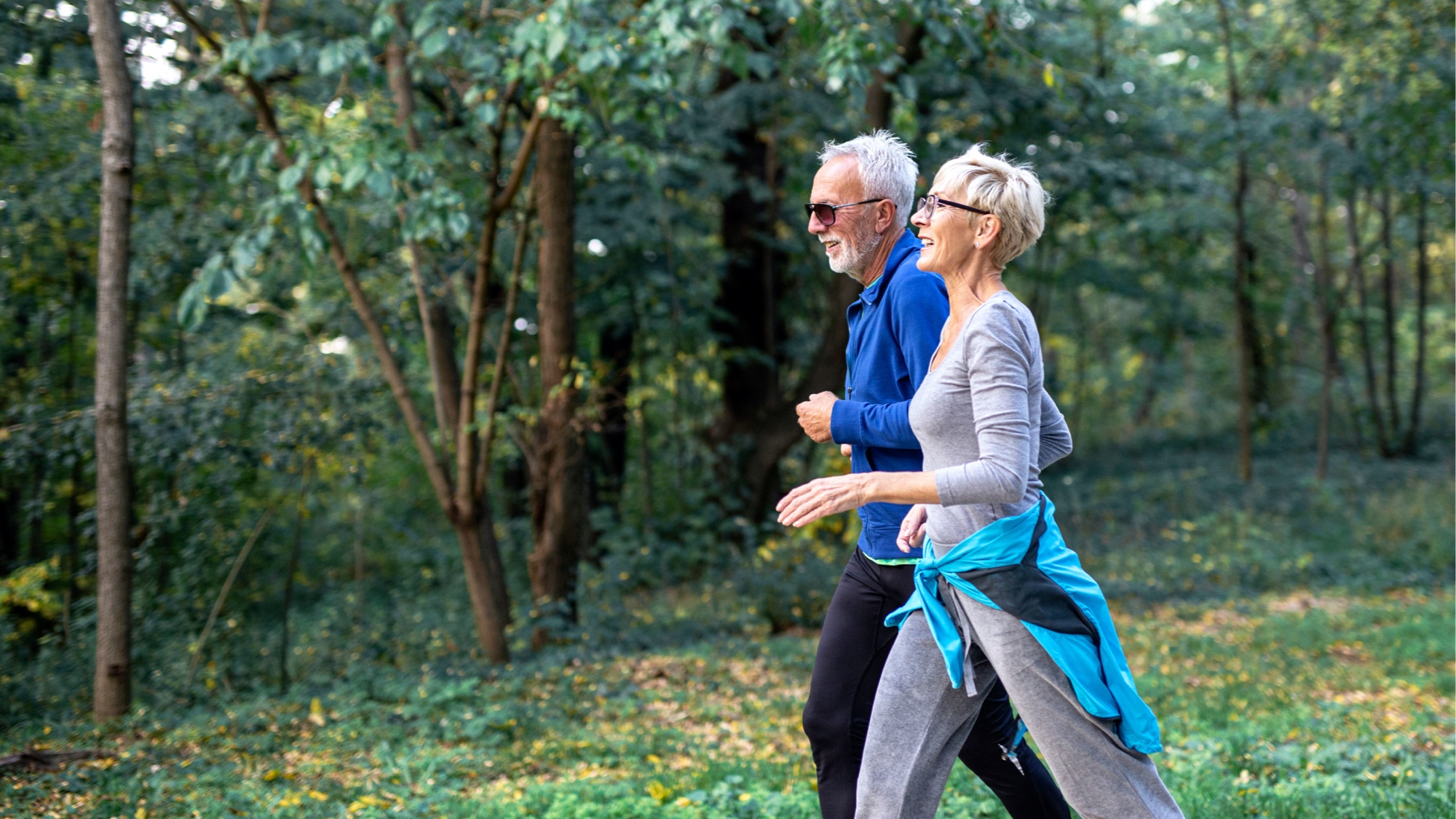 Older couple walking together outdoors.
