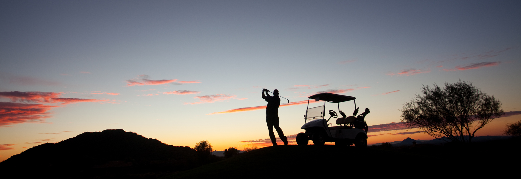 silhouette of a golfer against a sunset