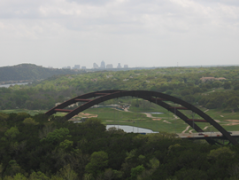 bridge in front of the distant Austin skyline