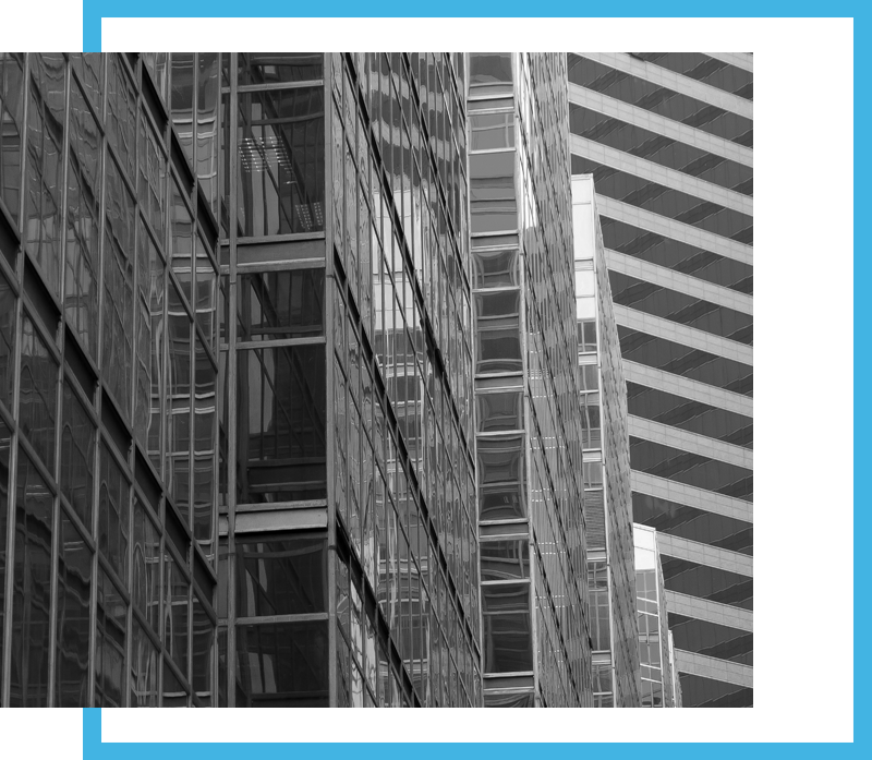 Black and white close-up of glass office buildings with modern geometric reflections, bordered by a bold blue frame.