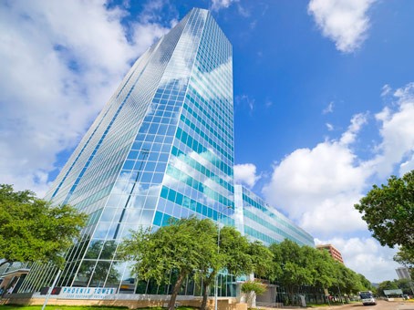 modern glass building reflecting white clouds and blue sky Houston, TX