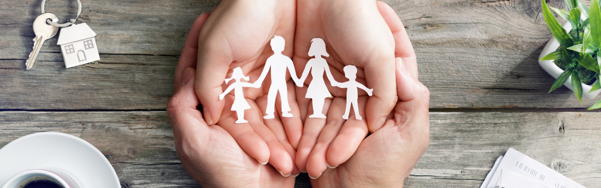 Two people's hands holding cutout image of family