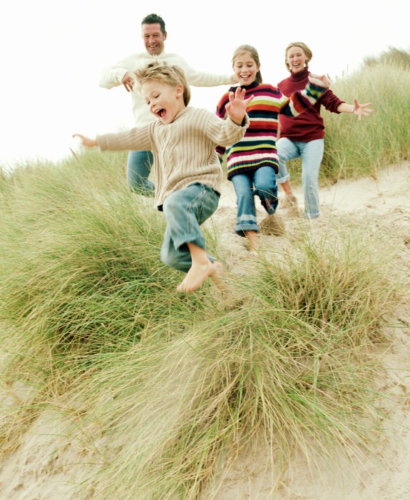 family-running-down-a-grassy-hill