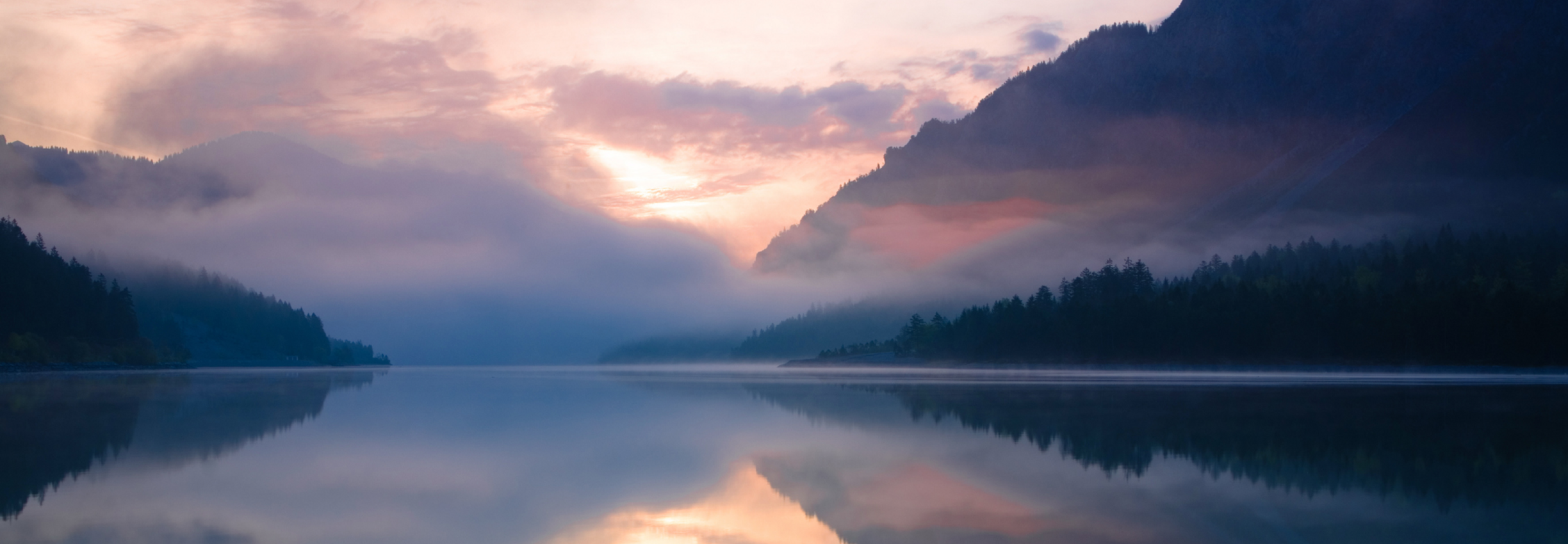Mist over a mountain lake at sunset