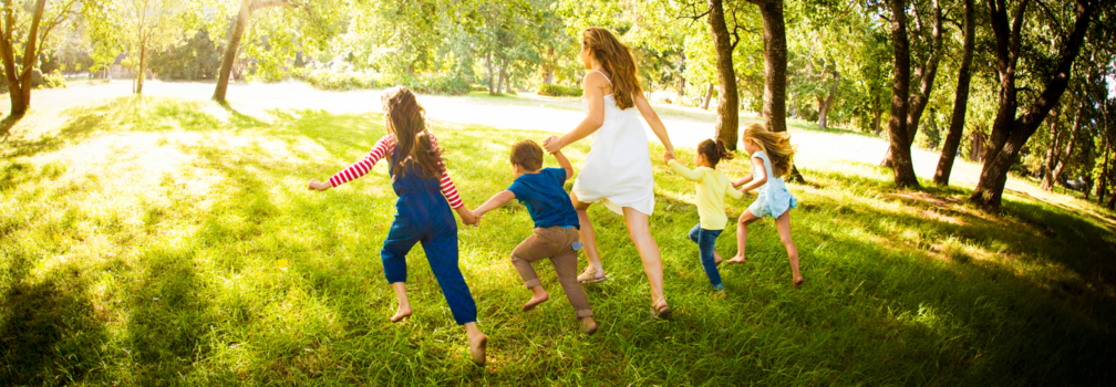 mother running with four children in a park