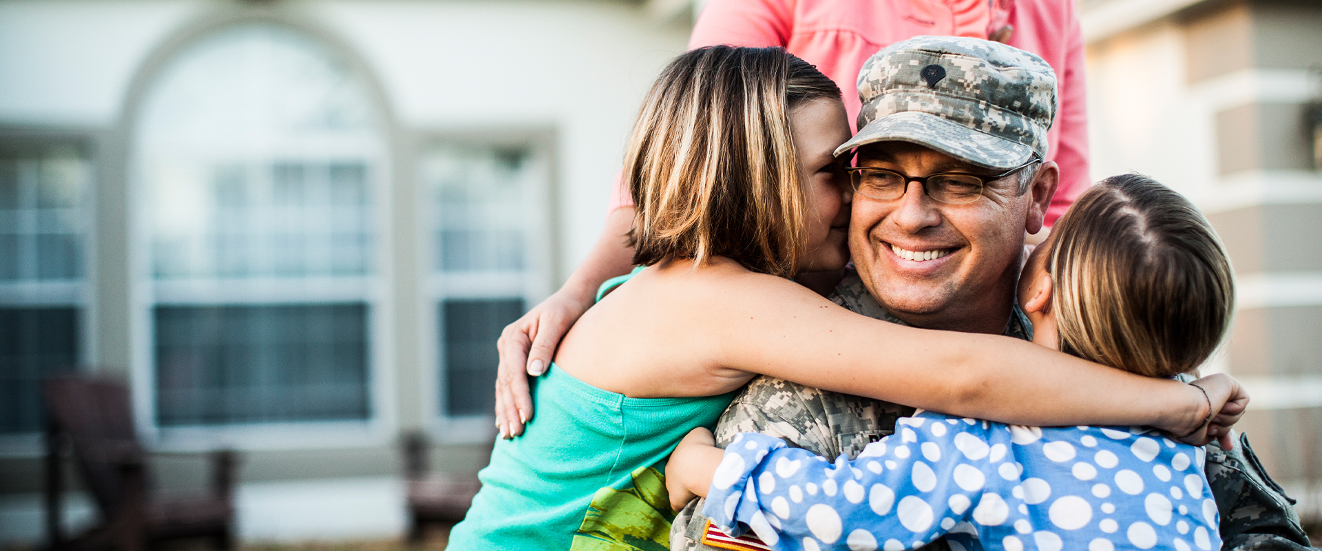 soldier hugging daughters