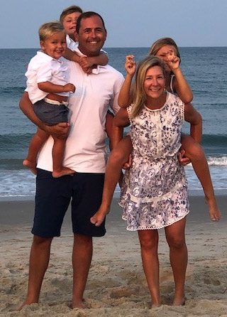Tom McCarty and family smiling on the beach