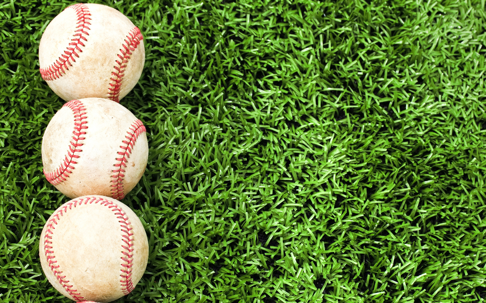 Baseballs laying in green grass