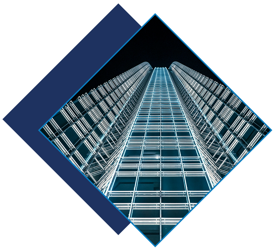 Upward view of a modern glass skyscraper illuminated at nigh