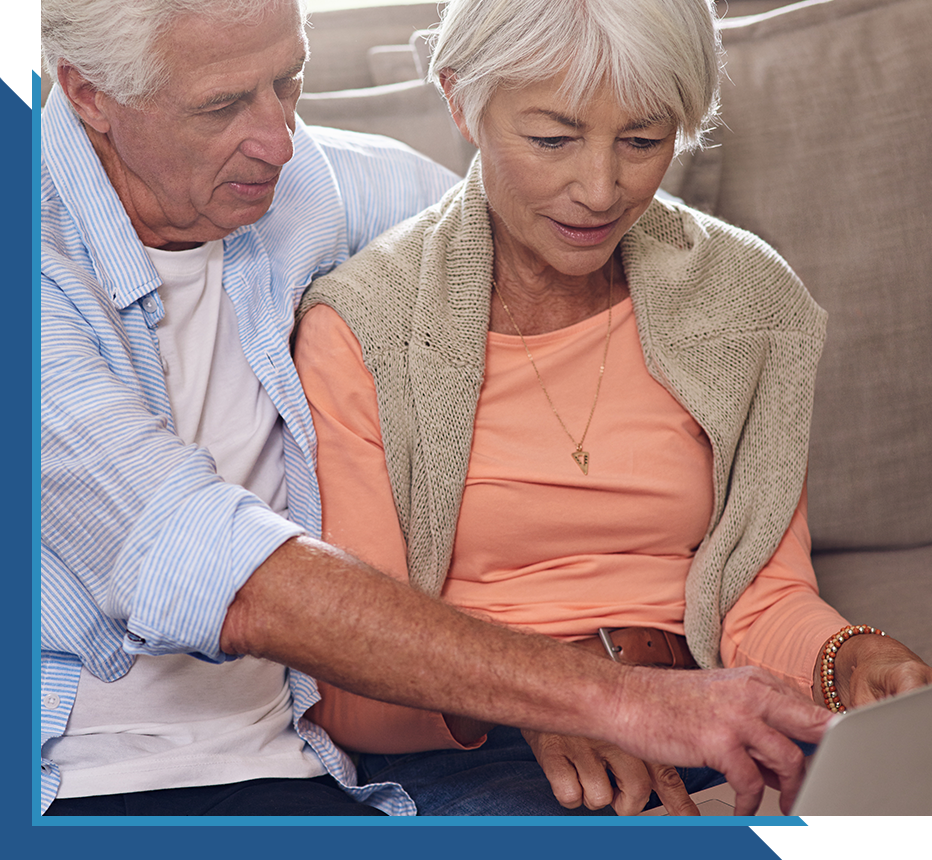 Older couple reviewing information together on a laptop at home.