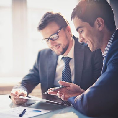 2 men in suits discussing documents