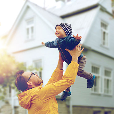 man outdoors lifting baby up