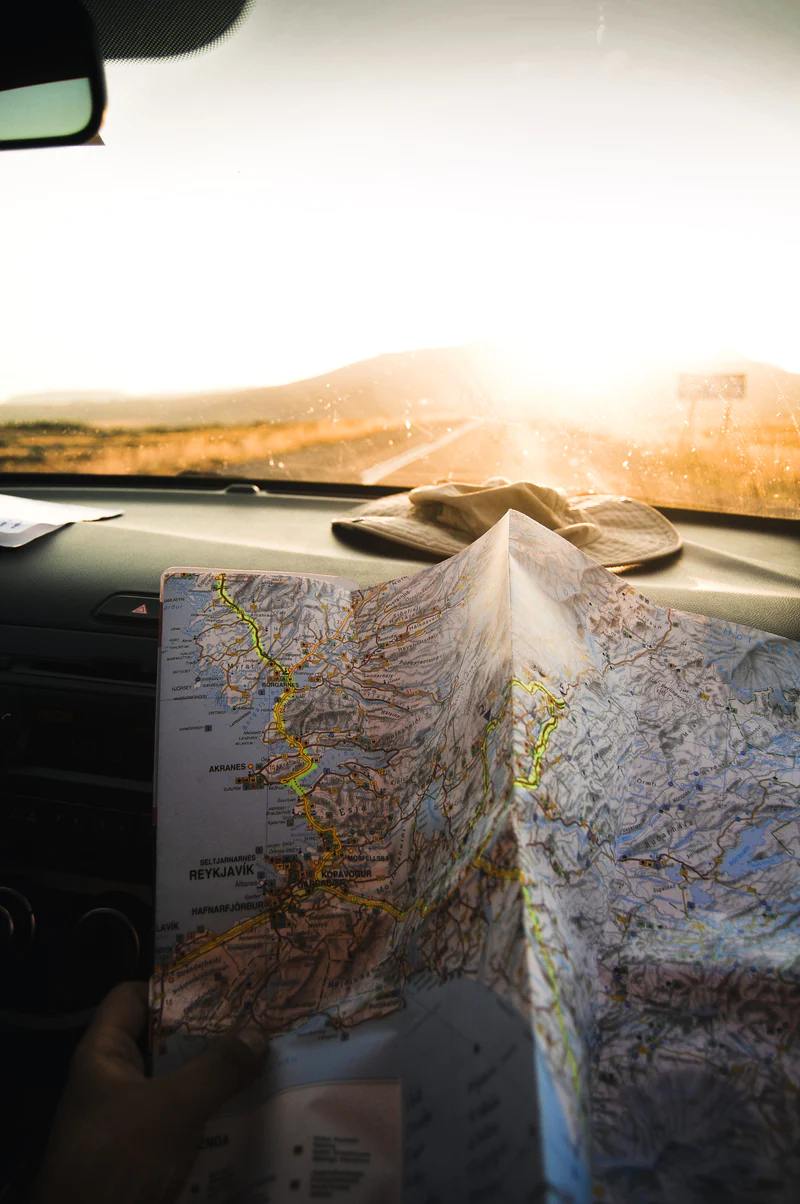 View Looking Out Windshield of Car With Map on Dashboard Image