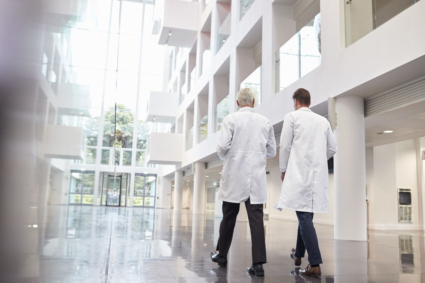 Small Version Two Doctors Talking While Walking Through Building Corridor Image