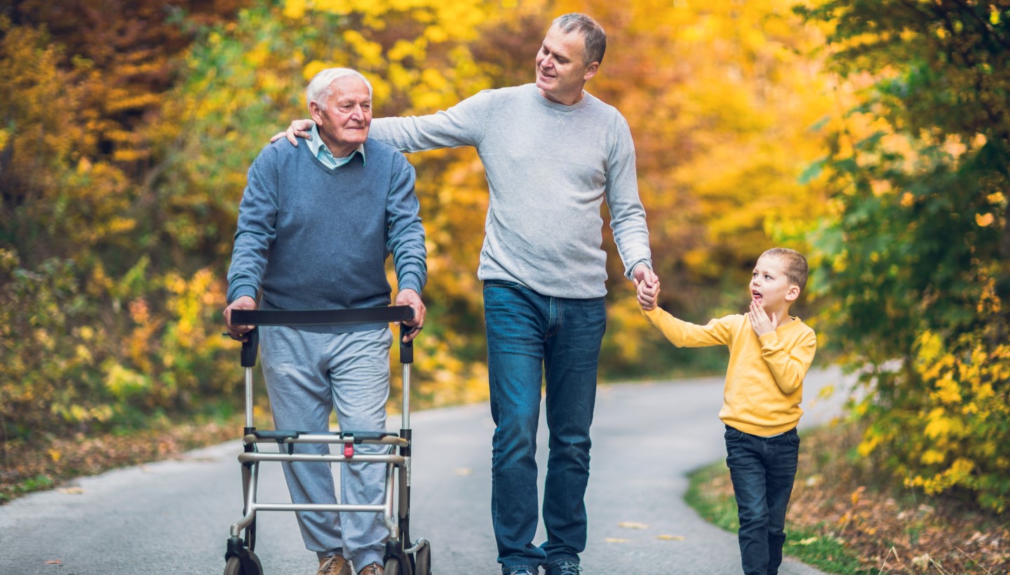 Man With Walker Walking on Path With Son and Grandson Image