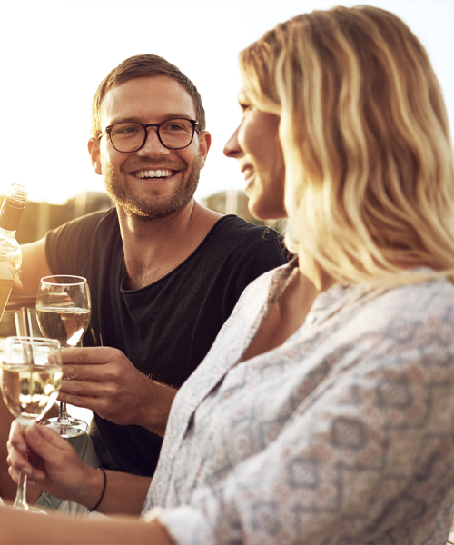 couple with wine glasses talking in golden light