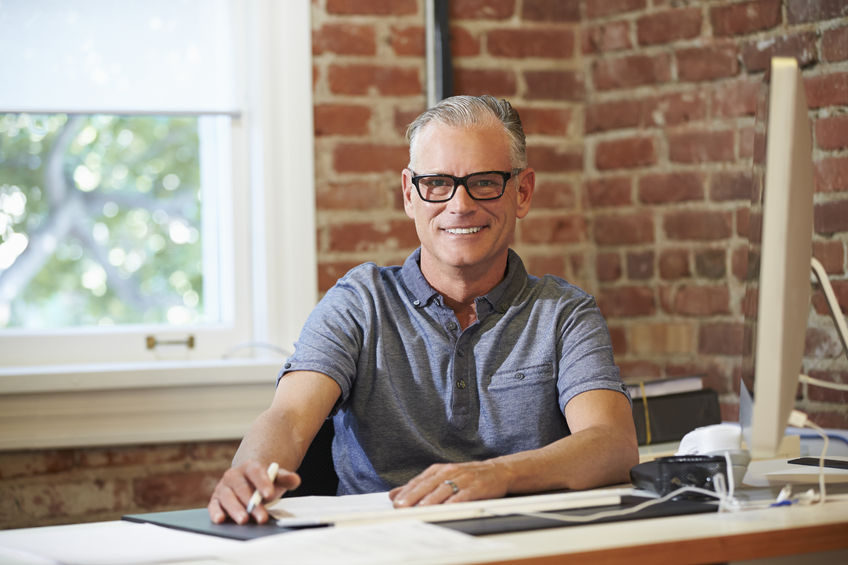 Man Sitting at Desk With Computer Smiling Image