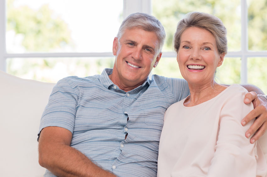 Picture of Couple Sitting on Couch Smiling at Camera Image