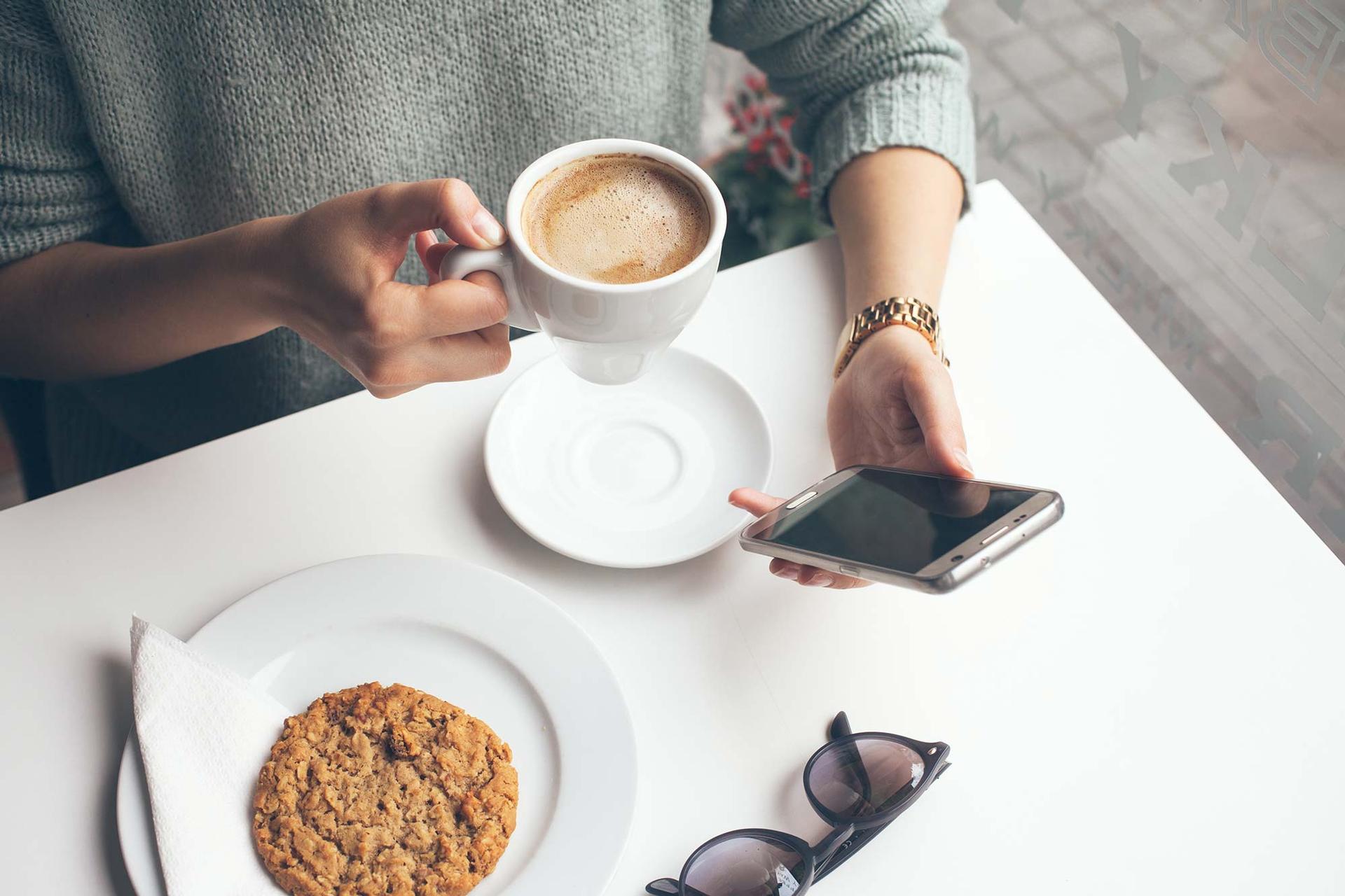 coffee, cookie, sunglasses, phone on table