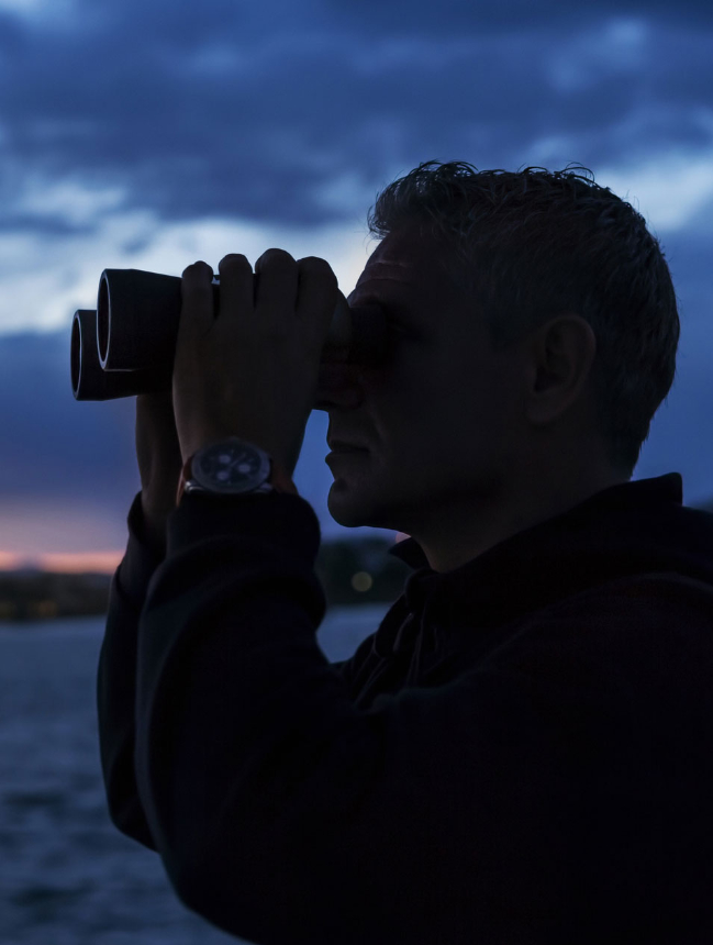 silhouette man looking through binoculars twilight