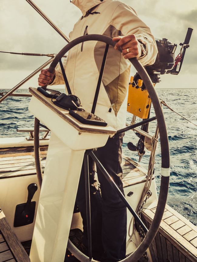 close up sailor holding wheel sailboat