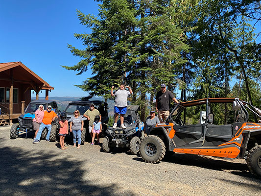Keri and her family standing in front of ATVs