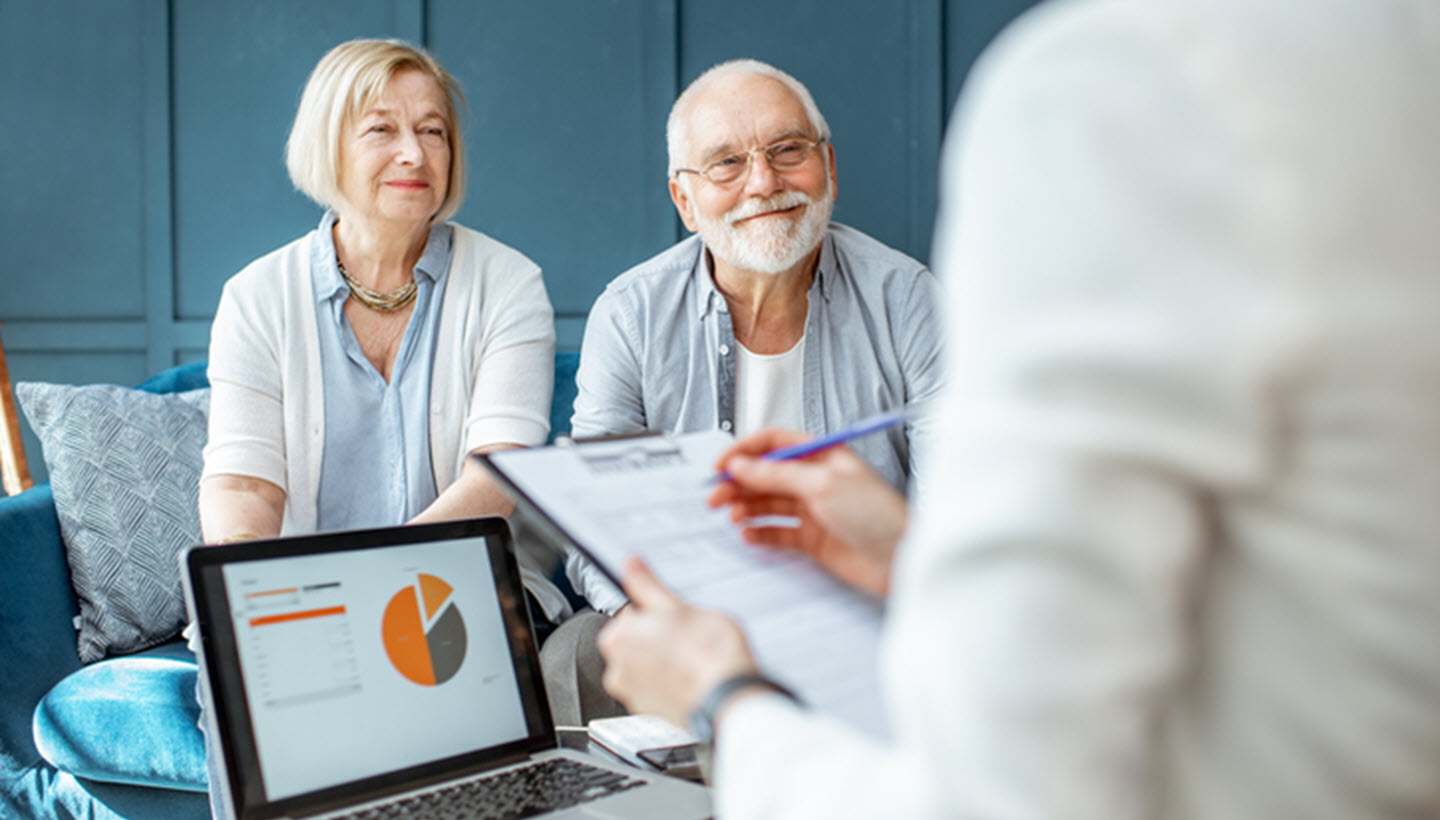 meeting with older couple clipboard form laptop with pie chart data