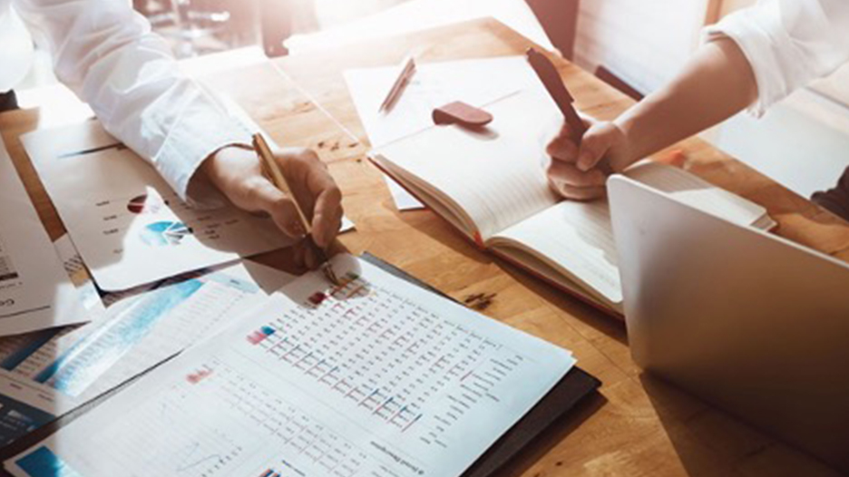 people working at a table looking over financial documents