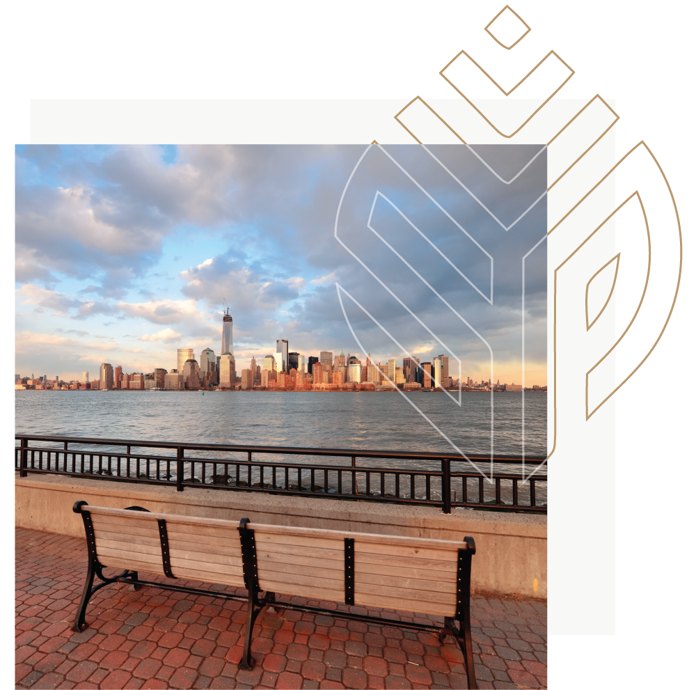 Photo of a bench overlooking the city surrounded by water