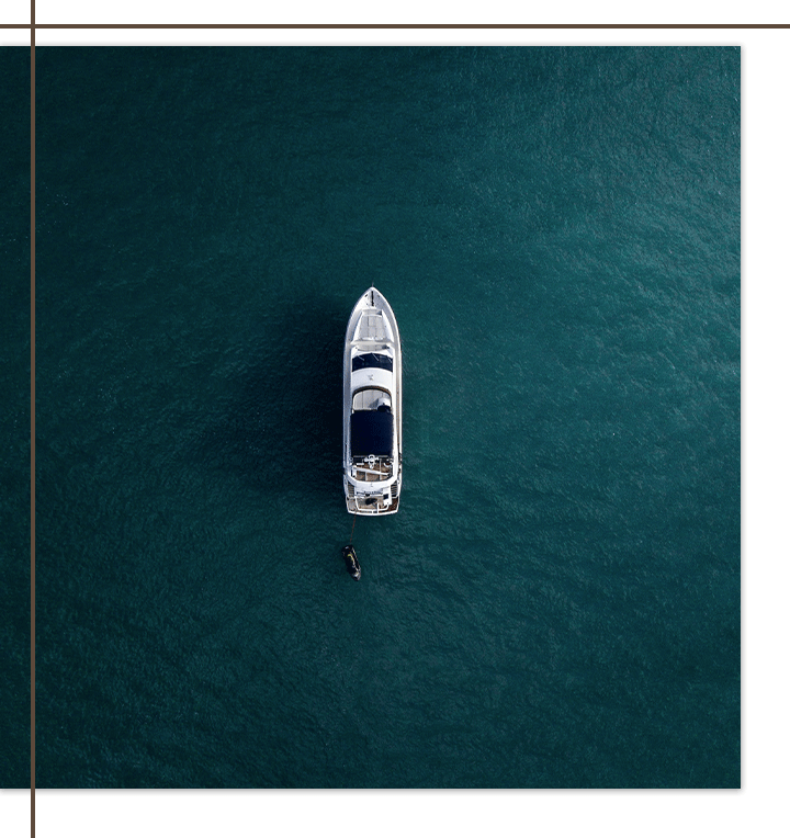 Aerial view of a luxury yacht floating on calm blue water.