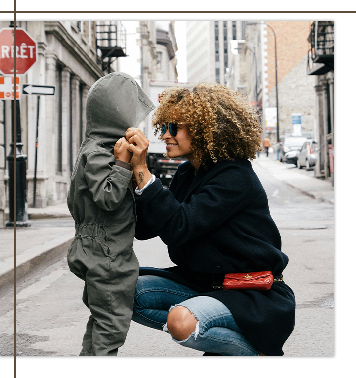 A mother and child sharing a tender moment on a city street.