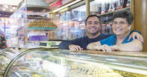 Two business owners standing behind bakery counter
