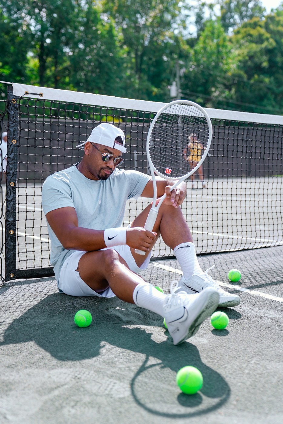 Emanuel Jones sitting courtside with a racquet after a tennis match