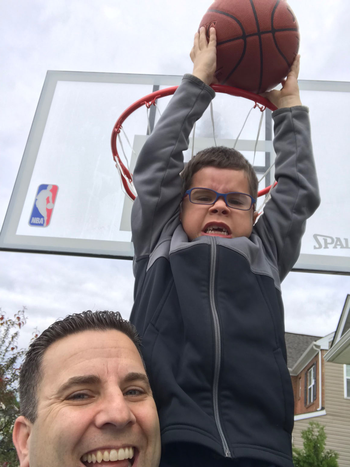 Marc helping son to dunk basketball