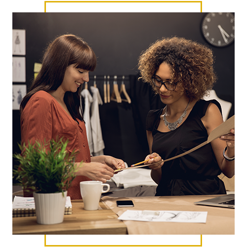 Two colleagues collaborate at a design studio, reviewing samples and sketches.