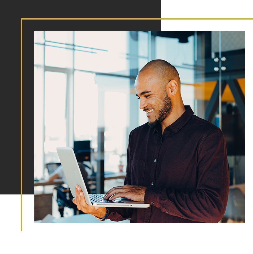 A professional works confidently on a laptop in a bright, modern office.