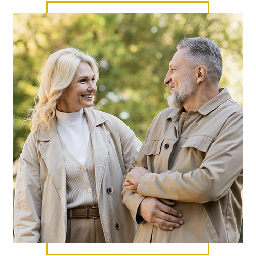 A smiling couple enjoys a pleasant walk outdoors together